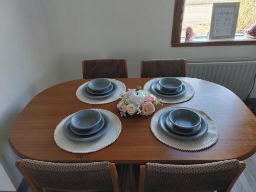 a wooden table with plates and hats and flowers on it at Westview in Buckie