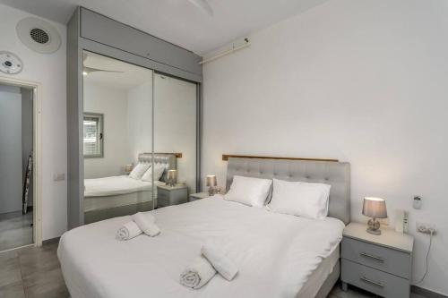 1 dormitorio con 1 cama blanca grande y 2 almohadas en New Branch Gindi Tower 1BR with Parking, en Tel Aviv