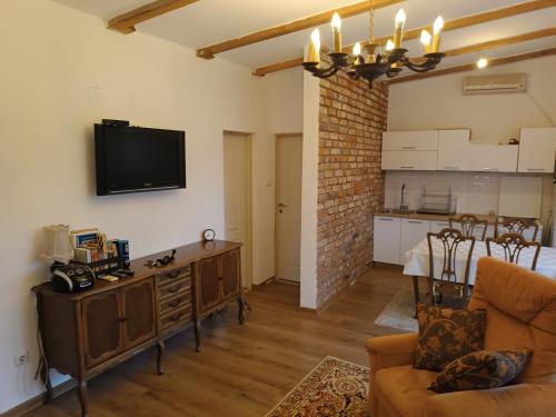 een woonkamer met een bank en een tv aan de muur bij Radusha Open 