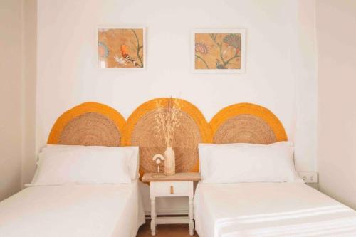 a bedroom with two beds and a table and two pictures at LC Apartaments Av del Mar in Castellón de la Plana