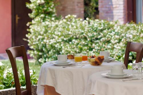 einen Tisch mit einem weißen Tischtuch und Getränken darauf in der Unterkunft Hotel Pausania in Venedig