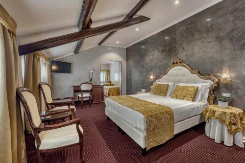 a bedroom with a large bed and a table and chairs at Hotel Pausania in Venice