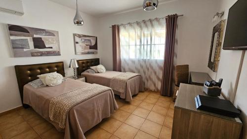 pokój hotelowy z 2 łóżkami i oknem w obiekcie Villa BONITA on Golf in El Descanso ,Caleta Fuste-Fuerteventura w mieście Caleta De Fuste