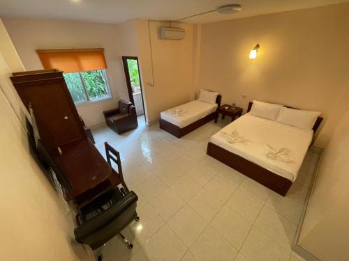 an aerial view of a bedroom with two beds and a piano at Hoang Kim Hotel in Vientiane