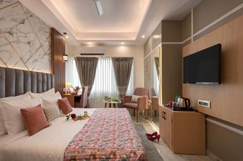 a hotel room with a bed and a flat screen tv at Hotel Sarang Palace - Boutique Stays in Jaipur
