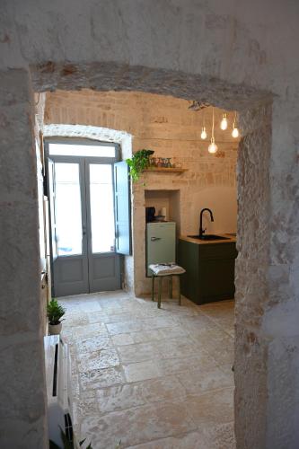a kitchen with a door in a stone building at La Casetta in Alberobello