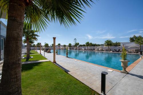 a swimming pool in a resort with palm trees at Paradice Hotel Luxury Suites-Near zorbas Beach-FREE Breakfast in Stavros