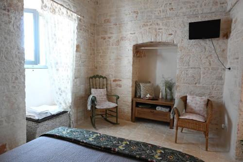 a bedroom with a bed and a desk and a mirror at La Casetta in Alberobello
