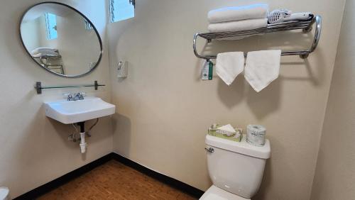 a bathroom with a toilet and a sink and a mirror at Stay Hotel Waikiki in Honolulu