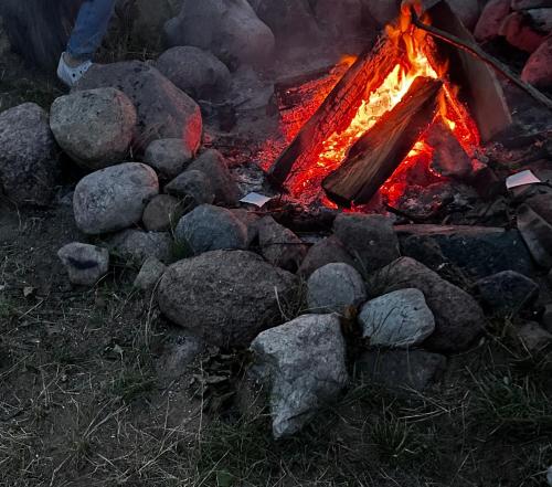 a campfire with rocks and a person standing next to it at Sterla - Masuria in Giżycko