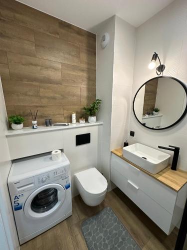 a bathroom with a washing machine and a sink at SkyTravel 26 Apartament Pileckiego Nowy Dwór Mazowiecki Airport Modlin 24H in Nowy Dwór Mazowiecki