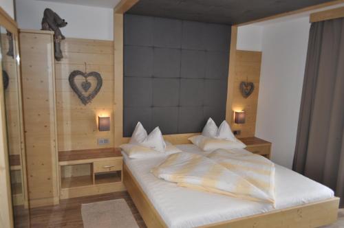 a bedroom with a bed with a heart on the wall at B&B - Apartments Sunnwies in Marlengo