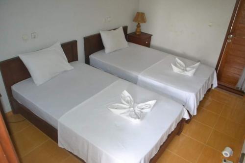 - 2 lits dans une chambre avec des draps blancs dans l'établissement Kiayazo ViBES Inn, à Gili Trawangan