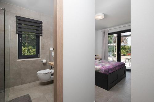 łazienka z łóżkiem, toaletą i prysznicem w obiekcie Luxury design Villa Maell with private pool and high level of privacy - WiiBuk w mieście Šišan