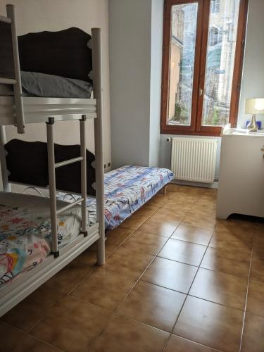 - une chambre avec des lits superposés et du carrelage dans l'établissement Appartement et salle de jeu, à Saint-Claude