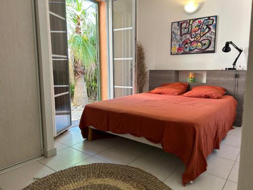 - une chambre dotée d'un lit avec des oreillers orange dans l'établissement Maison 6 personnes SaintFlorent, à Saint-Florent