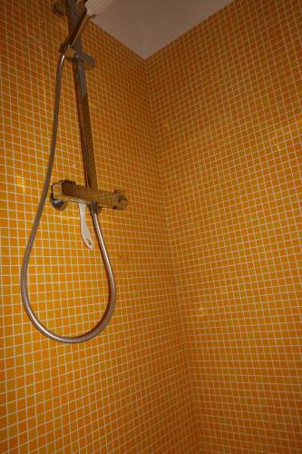 La salle de bains est pourvue d'une douche et d'un mur carrelé jaune. dans l'établissement Maison 6 personnes SaintFlorent, à Saint-Florent