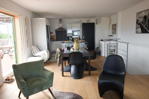 un salon avec une table et des chaises et une cuisine dans l'établissement Maison 6 personnes SaintFlorent, à Saint-Florent