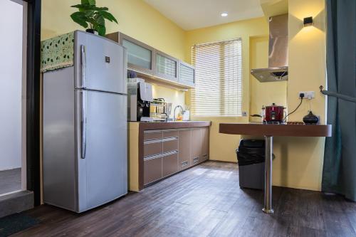 a kitchen with a white refrigerator and a table at R S Home in Tawau