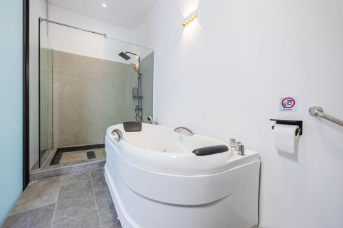 a white bathroom with a sink and a shower at R S Home in Tawau