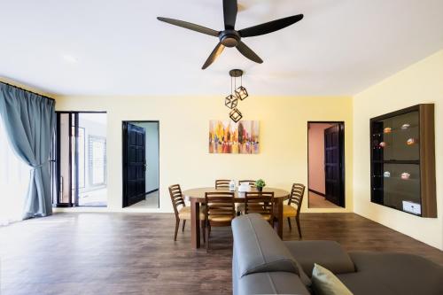 a dining room and living room with a ceiling fan at R S Home in Tawau