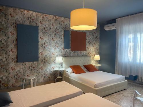 a bedroom with two beds and a large window at Central Suite Bed&Breakfast in Bologna