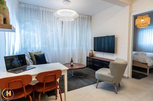 a living room with a table with a laptop on it at Eshkol Housing Haifa-Disraeli Urban & Business boutique Apartments complex in Haifa