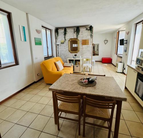 sala de estar con mesa y sofá amarillo en Casa Nonna Elide, en Besozzo