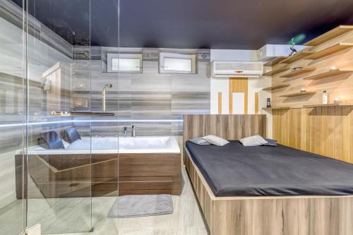 1 dormitorio con cama, bañera y lavamanos en Private Wellness Apartment, en Trebnje