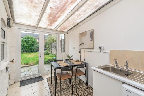 a kitchen with a table and a sink at Wood House by EDEN Accommodation - 3 Bedroom Whole House, Sleeps 6 in Kettering