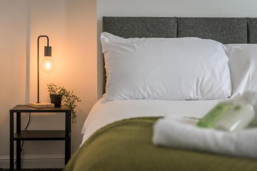a bed with a white pillow and a side table at Wood House by EDEN Accommodation - 3 Bedroom Whole House, Sleeps 6 in Kettering