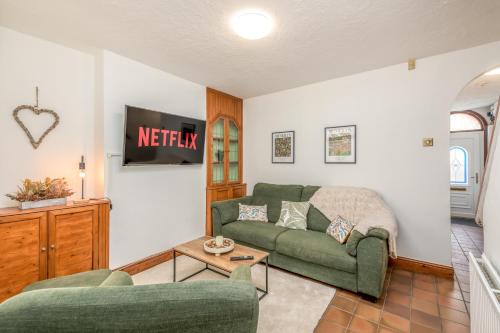 a living room with a green couch and a table at Wood House by EDEN Accommodation - 3 Bedroom Whole House, Sleeps 6 in Kettering