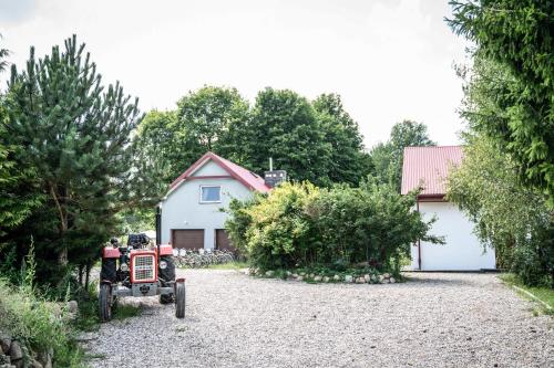 a toy tractor parked in front of a house at Bezkresne- Domy w Sidorach in Jeleniewo