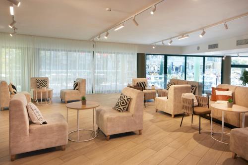 a waiting room with chairs and tables and windows at Hotel Marvel All Inclusive - FULLY RENOVATED FREE Beach Access in Sunny Beach