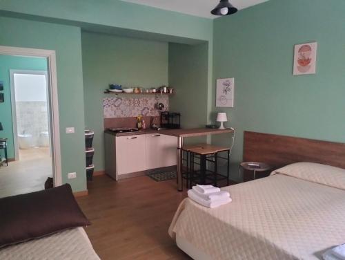 a room with two beds and a kitchen with a counter at INCASTRO B&B IN CROTONE in Crotone