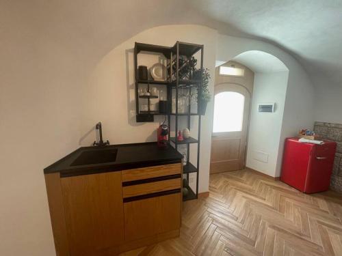 a kitchen with a sink and a red refrigerator at 9CENTO B&B and Private SPA in Montenero Val Cocchiara