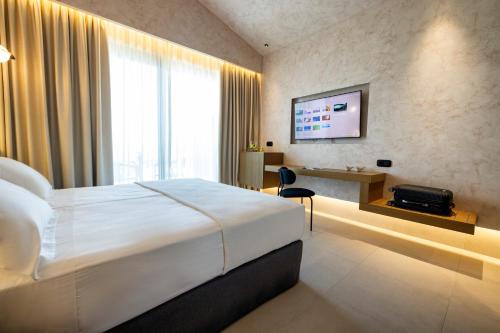 a hotel room with a bed and a television at Anasa Luxury Resort in Elaiokhórion