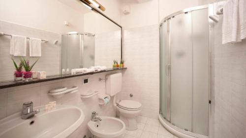 a bathroom with a toilet and a sink and a shower at Hotel Il Telamonio in Talamone