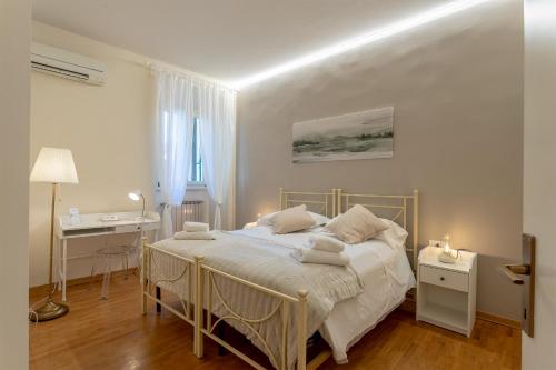 um quarto branco com uma cama e uma secretária em La Perla Del Borgo Apartment em Florença