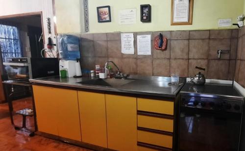 a kitchen with a sink and a stove at Cabaña Casa Amarilla in Ciudad Lujan de Cuyo