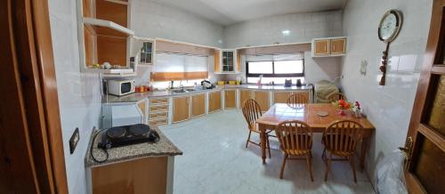 a kitchen and dining room with a table and chairs at Feel home always in Amman