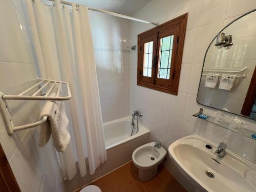 uma casa de banho com um lavatório, um WC e uma banheira em El retiro hotel rural em Moratalla