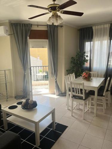 a living room with a table and chairs and a ceiling fan at Piso pineda in Monforte de Lemos