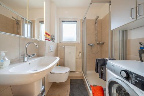 a bathroom with a sink and a washing machine at Private Apartment in Hannover