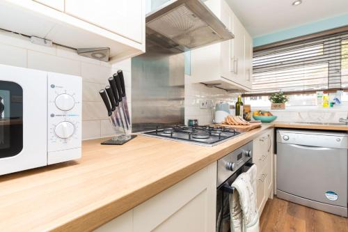 a kitchen with a stove and a microwave at Rivermead in Horsham