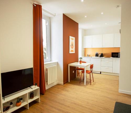 un salon avec une table et une cuisine dans l'établissement Le Terracotta - Joli studio Metro D Valmy et quais de Saone, à Lyon