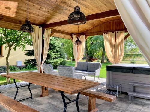 eine Terrasse mit einem Holztisch und einem Grill in der Unterkunft Siedlisko pod Kasztanem in Garwolin