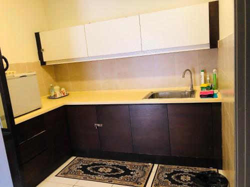 バンティングにあるSea view apartment Gold Coast Moribのキッチン(ブラウンキャビネット、シンク付)