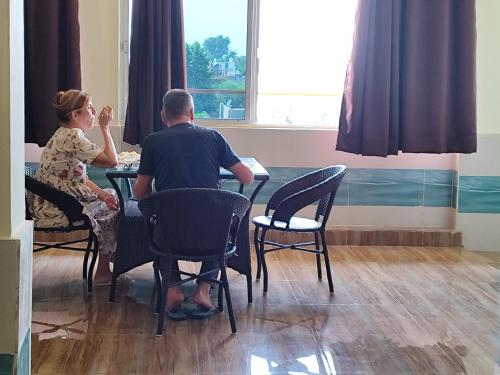 a man and a woman sitting at a table at Sunrise Homestay Agra Near Taj Mahal in Agra