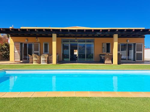 a swimming pool in front of a house at VILLA PARADISE in La Guirra